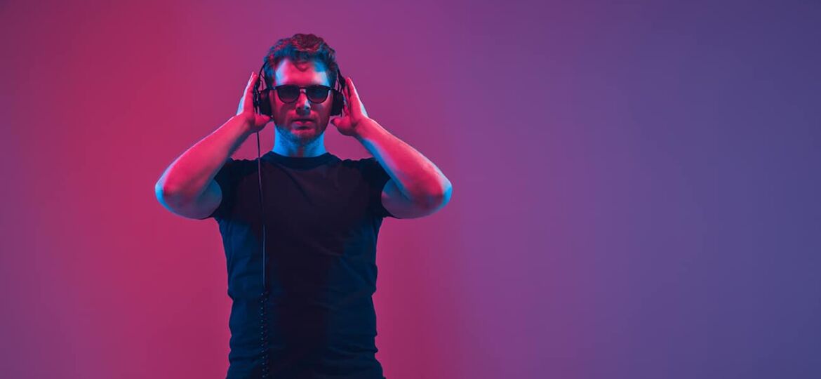 Mann hört Spotify Ads vor lila rotem Hintergrund