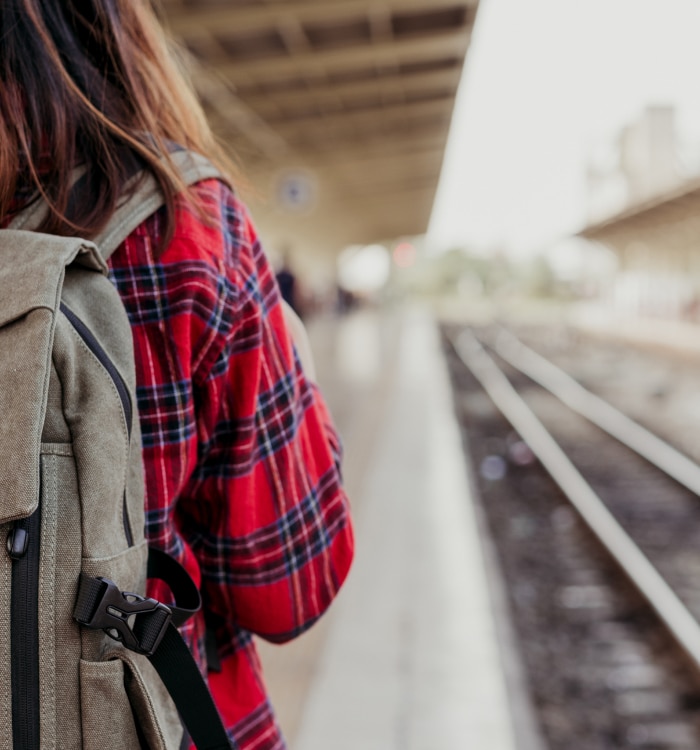 frau-mit-Rucksack-auf-bahnsteig